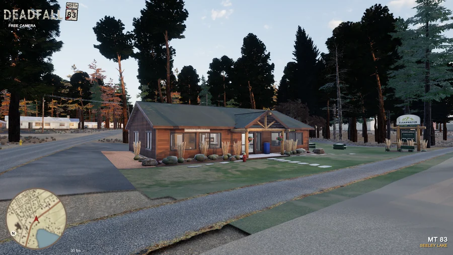In-engine free-camera view: The Clearwater Montana Properties office, timber entrance and roadside sign in golden-hour light. Original minimap and location HUD remain visible.