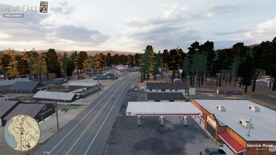In-engine free-camera view: A low aerial view along Highway 83 through downtown Seeley Lake, with Rovero’s in the foreground. Original minimap and location HUD remain visible.