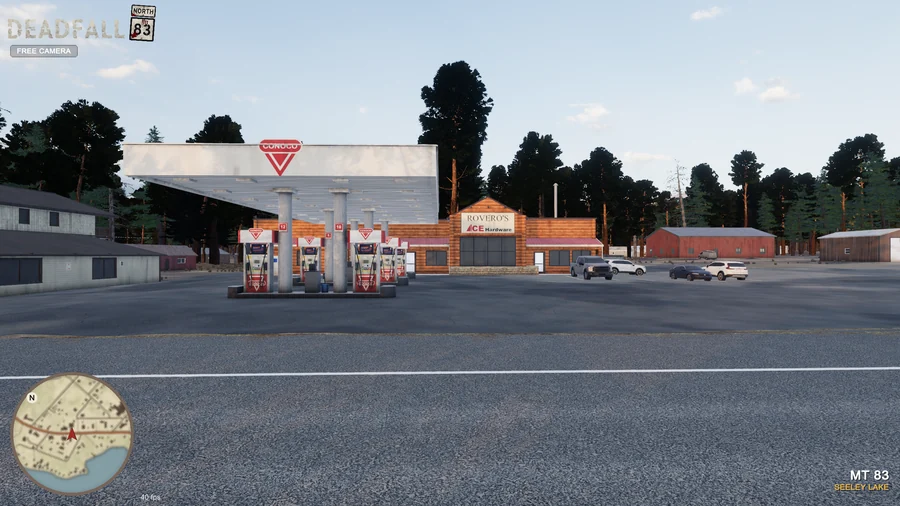 In-engine free-camera view: Rovero’s storefront and Conoco pump canopy viewed from across the highway at golden hour. Original minimap and location HUD remain visible.
