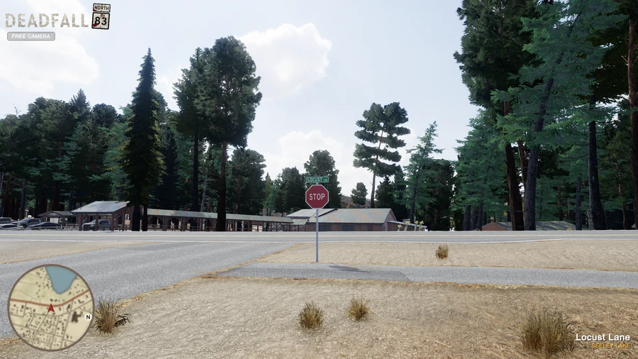 In-engine free-camera view of the Locust Lane intersection in Seeley Lake, with a stop sign, trees and buildings.